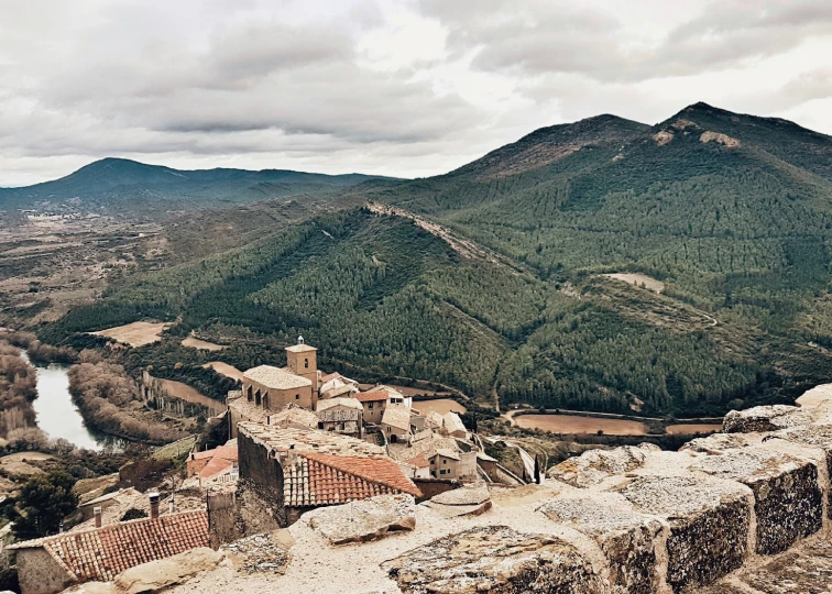 a scenic view of an ancient village and a river