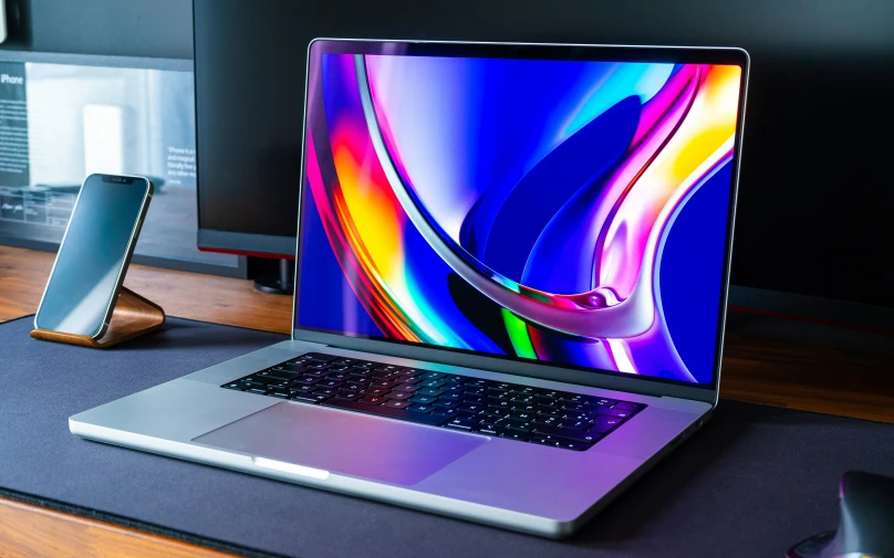 a laptop sitting on a desk next to a phone