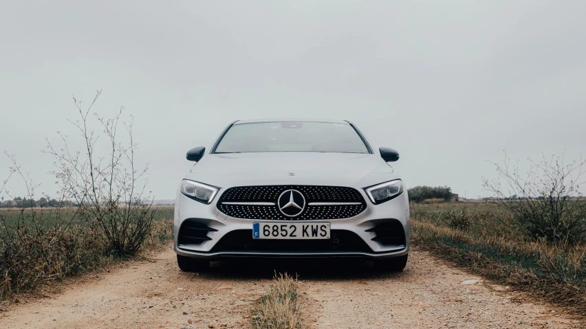 the mercedes cla is parked on a gravel road in the country