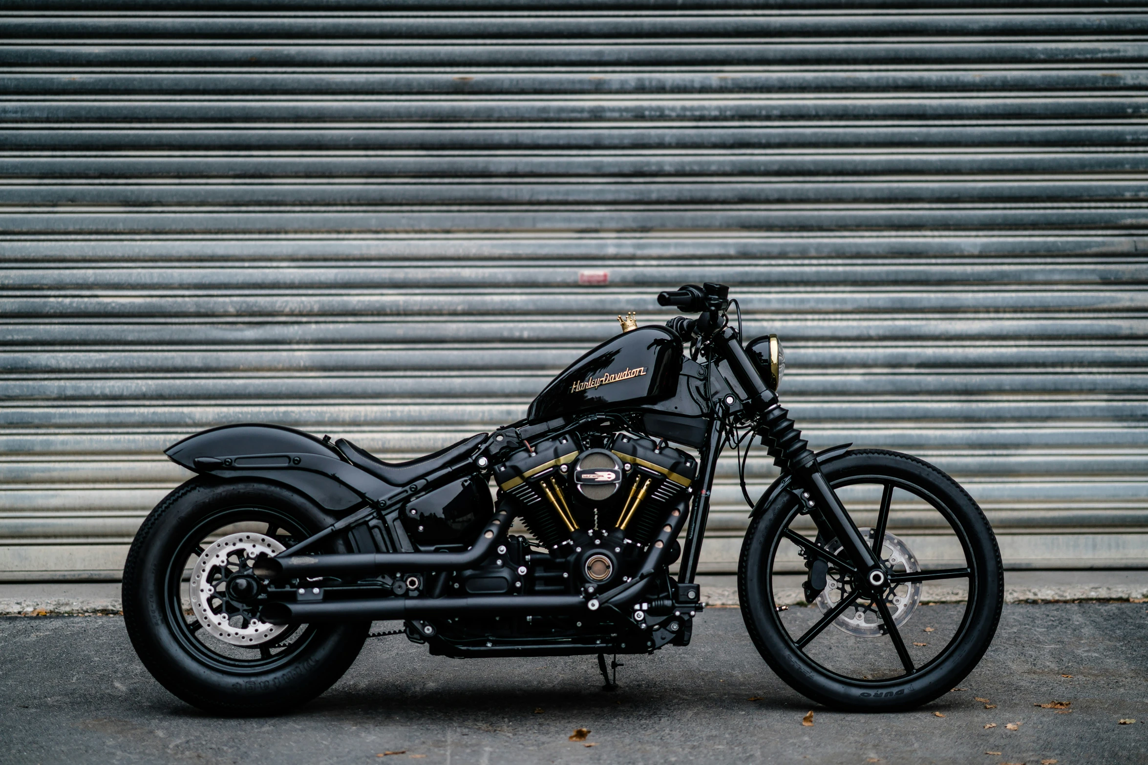 a custom motorcycle sits parked near a warehouse door