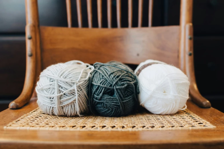 three balls of yarn laying on top of a chair