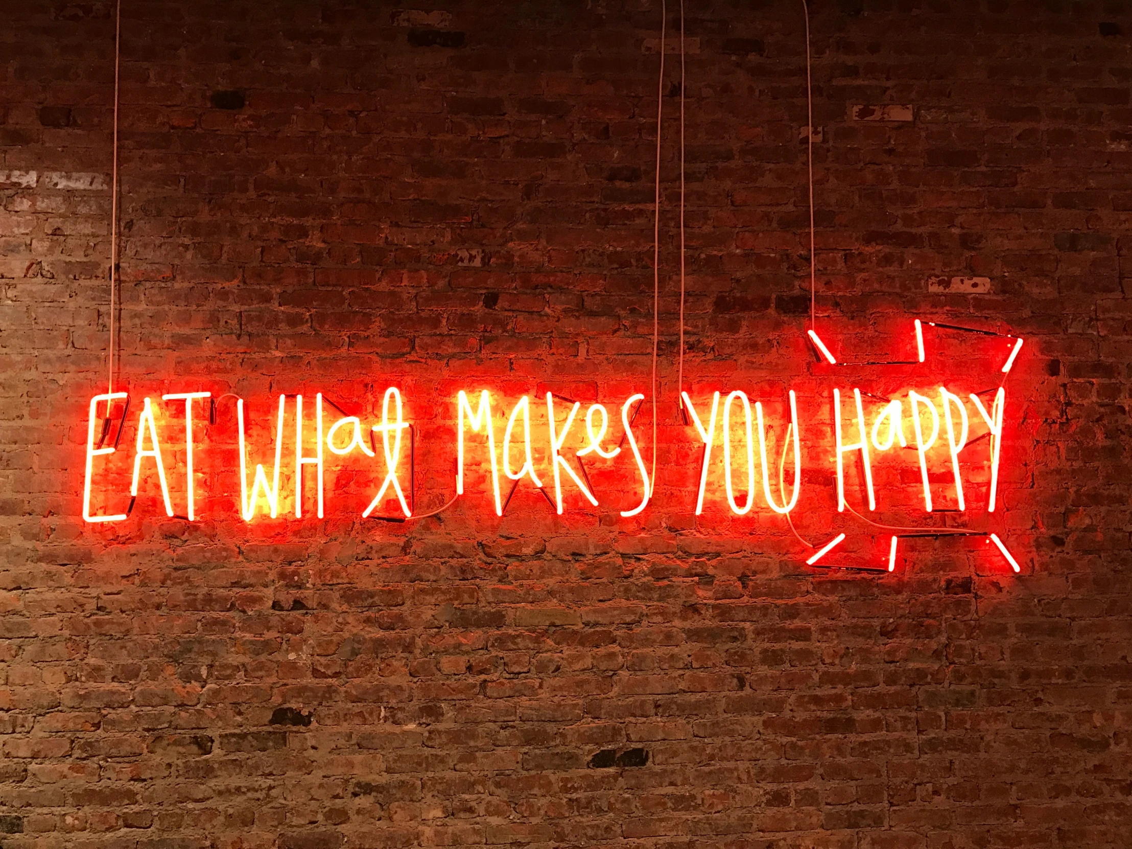 there is a neon sign that says eat what makes you happy