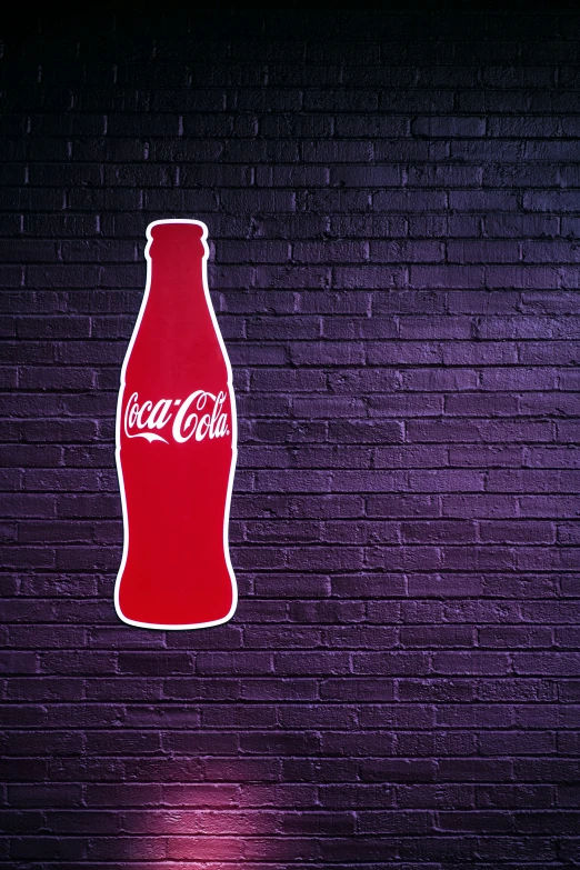 a large coke bottle sitting in the middle of a brick wall