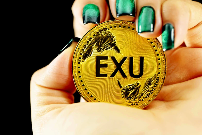 an exu gold token is shown in front of two hands