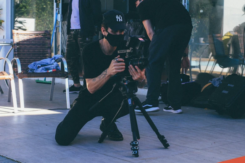 a man sitting on top of a tripod near another person