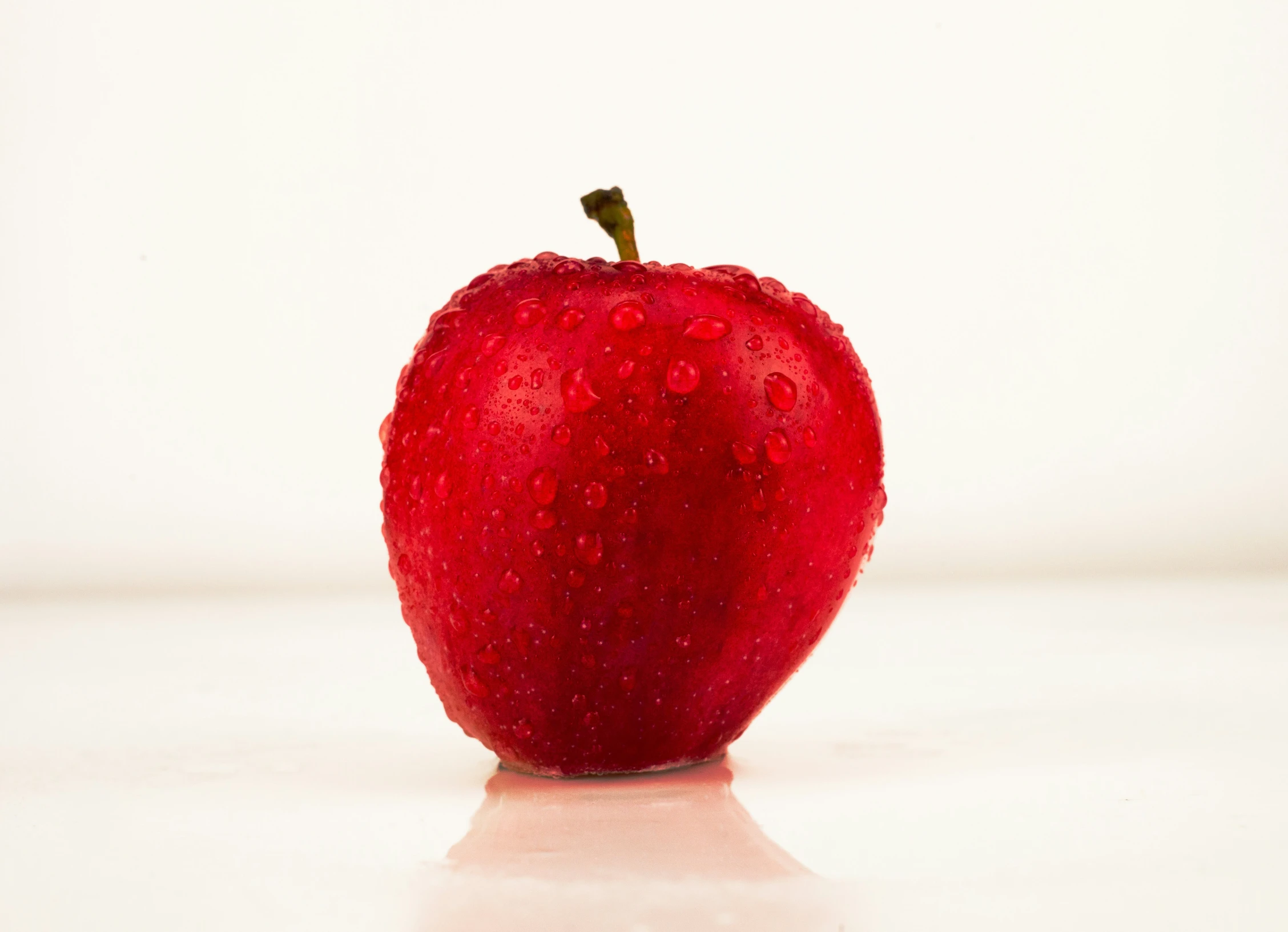 an apple is placed in front of the white wall