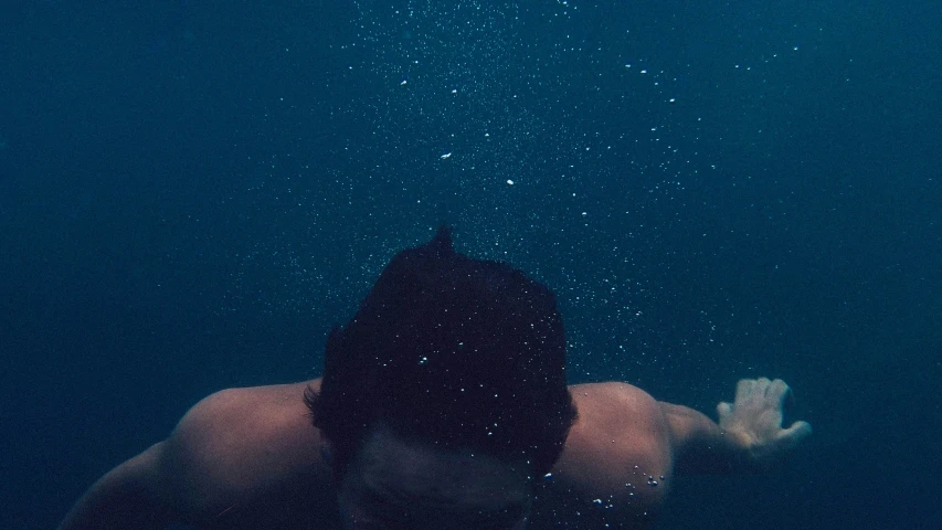 a man floating in the water while holding his arm out to the side