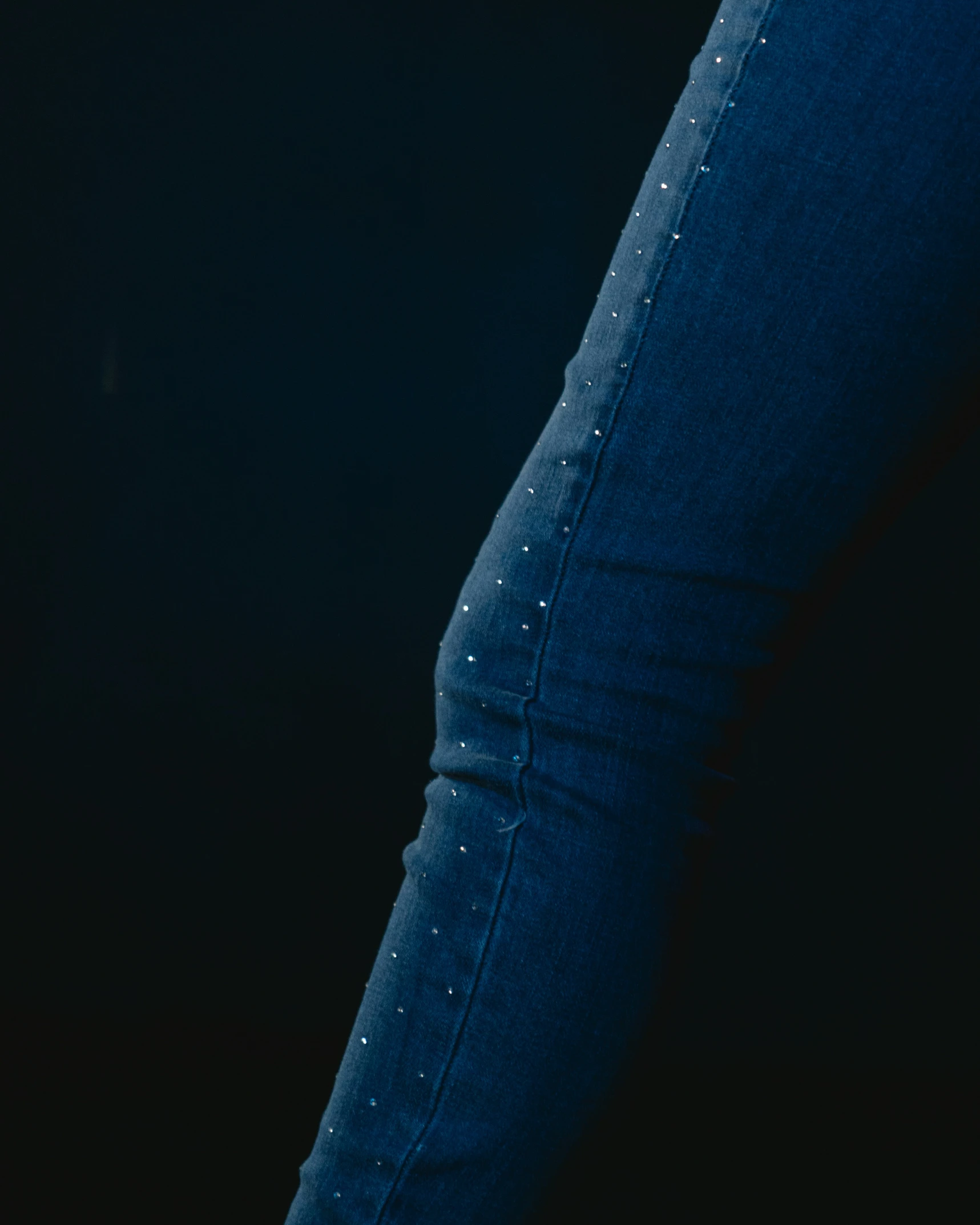 a woman wearing skinny jeans with studs on the thighs