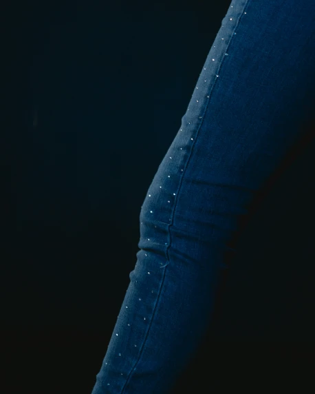 a woman wearing skinny jeans with studs on the thighs