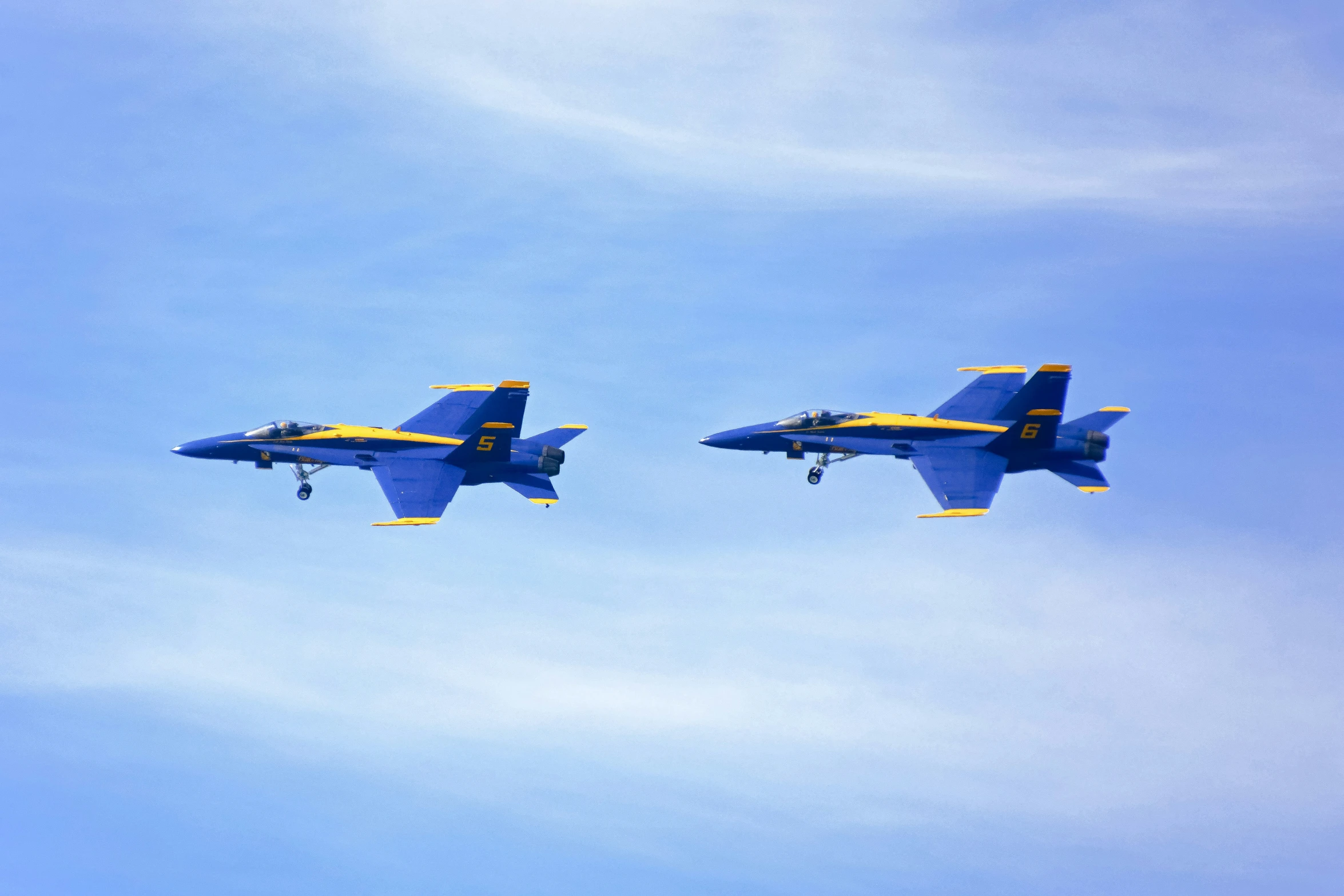 two jet planes flying close to each other in the sky