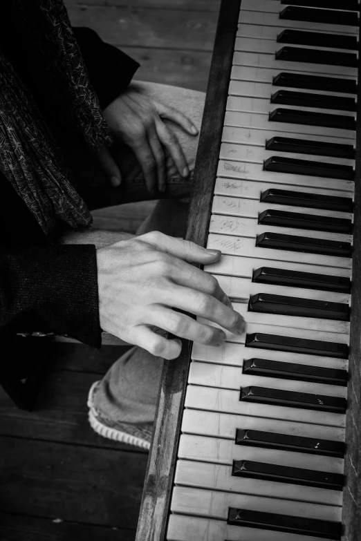 the hand is on the keys of the piano