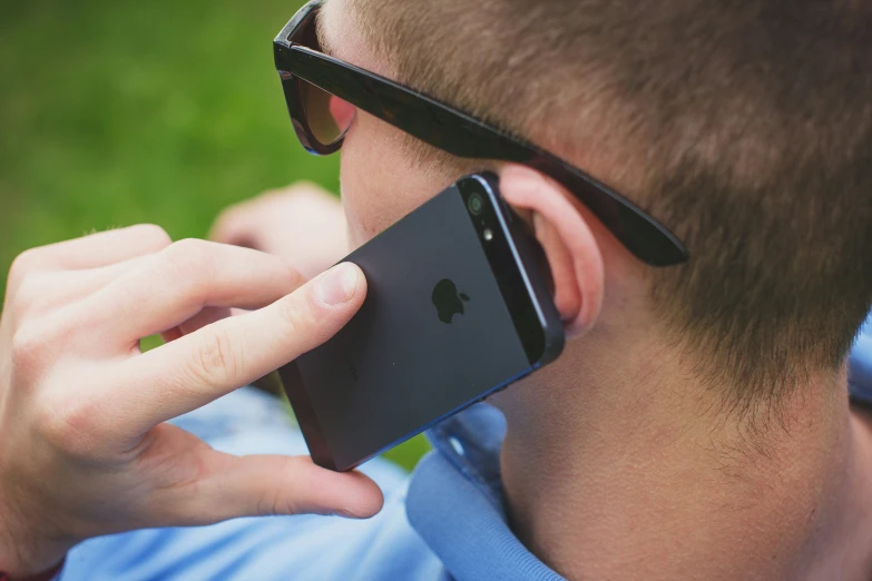 a man holding his smart phone to his ear while using it