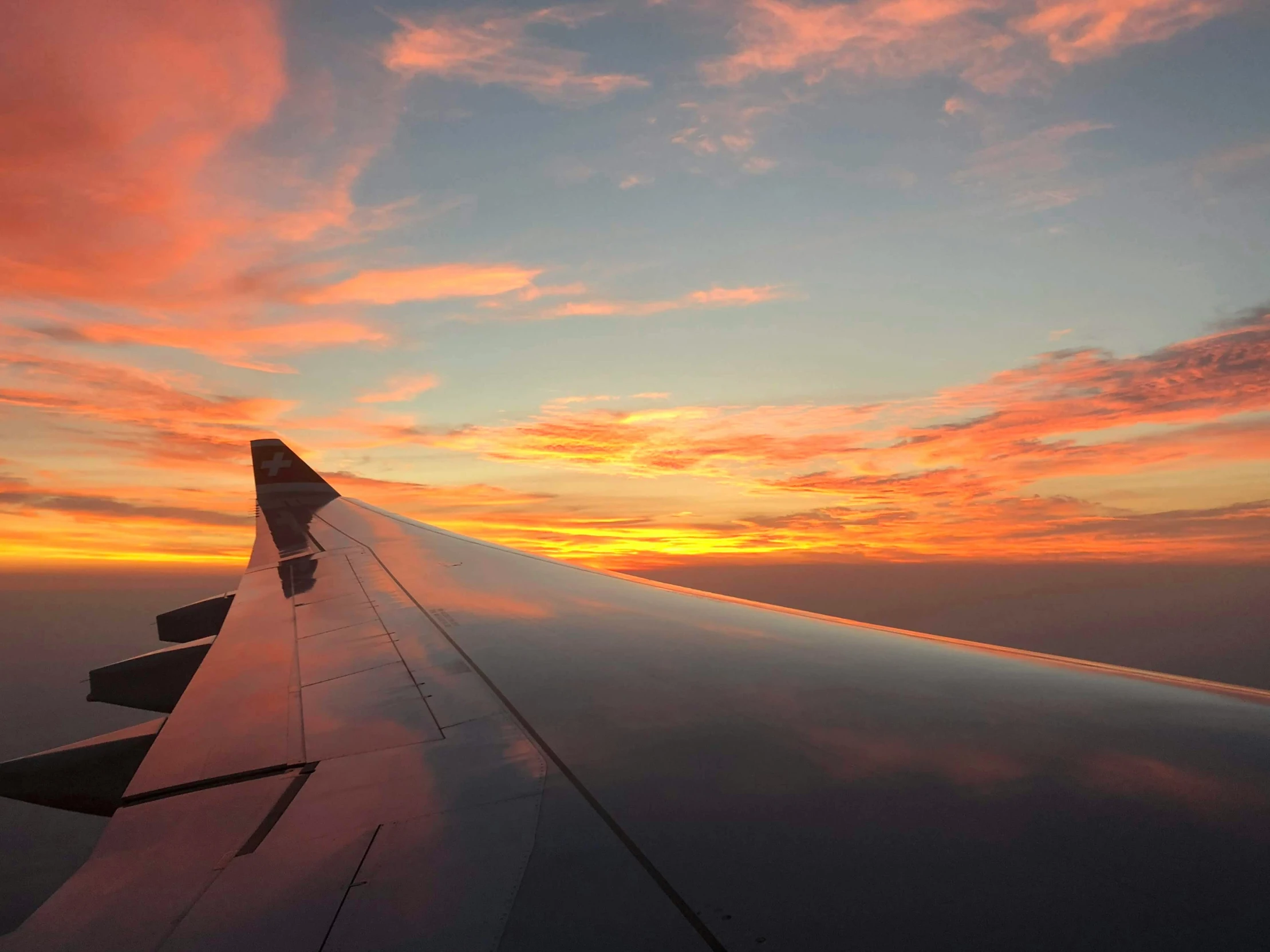 a view from an airplane window showing the wing and sky