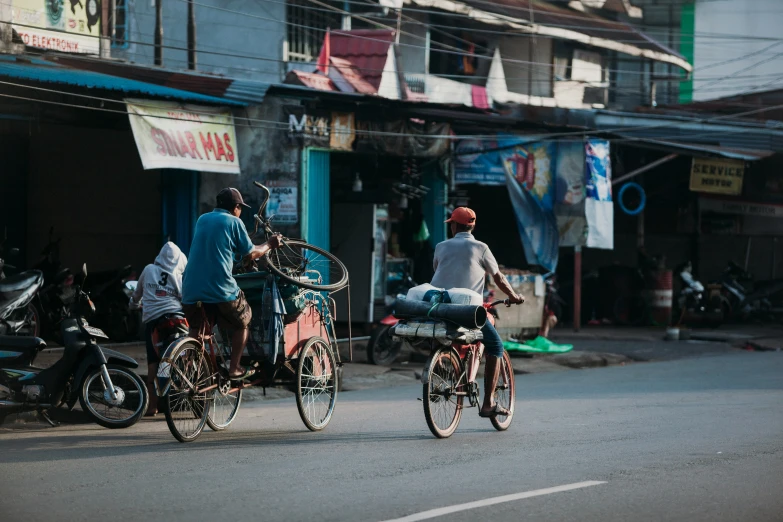 a couple of people riding on the back of bikes down a street