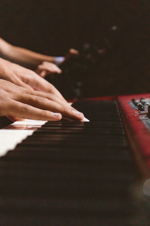 hands playing the piano while someone plays them