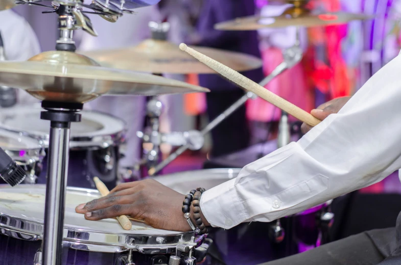 a close up of hands with a drum set