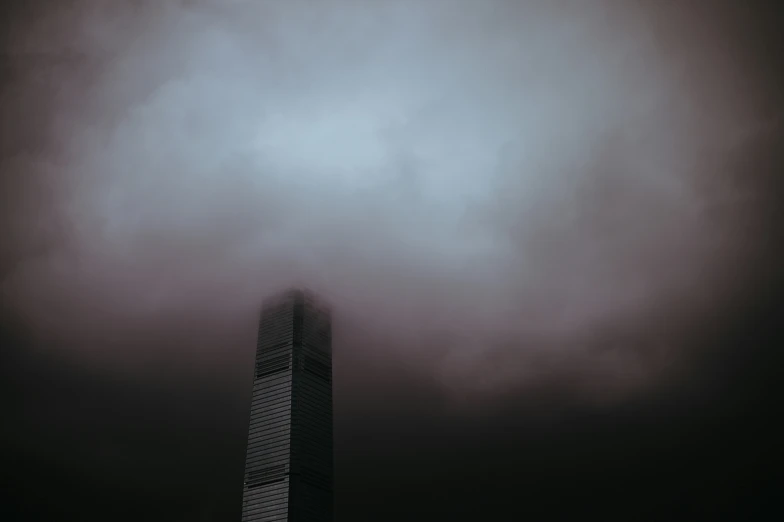 a tall building sitting under a very dark sky