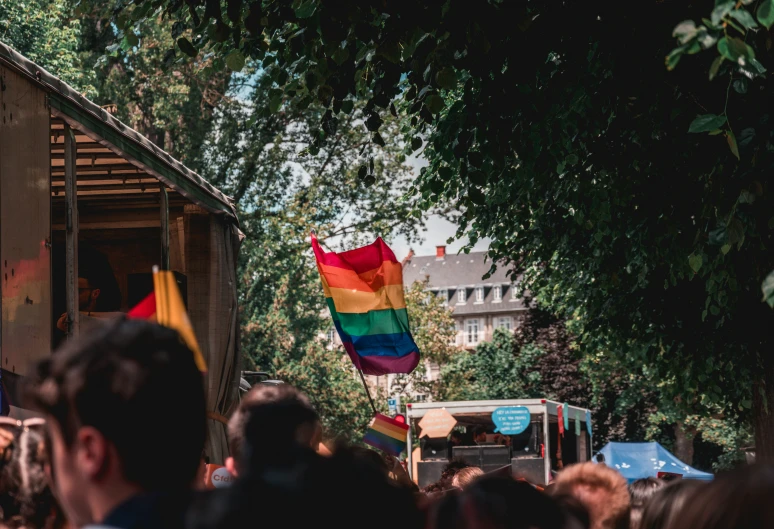 the rainbow flag in the foreground is waving with pride