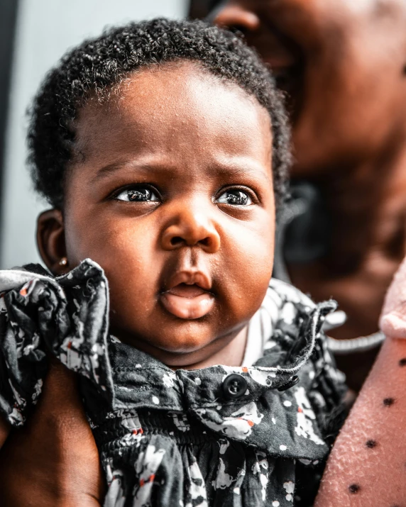 a baby sticking it's tongue out and looking into the camera