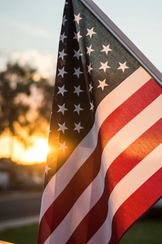 american flags blowing in the wind next to a car