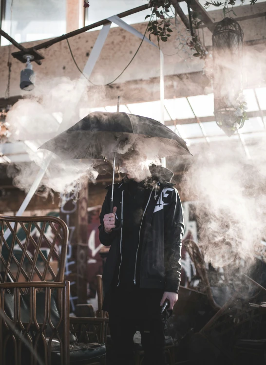 a man standing in front of an umbrella surrounded by steam