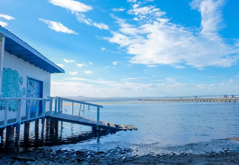 a small dock on a lake with a blue building