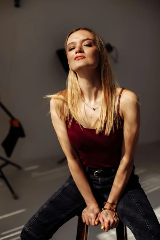 the woman is sitting on top of a stool and looking up