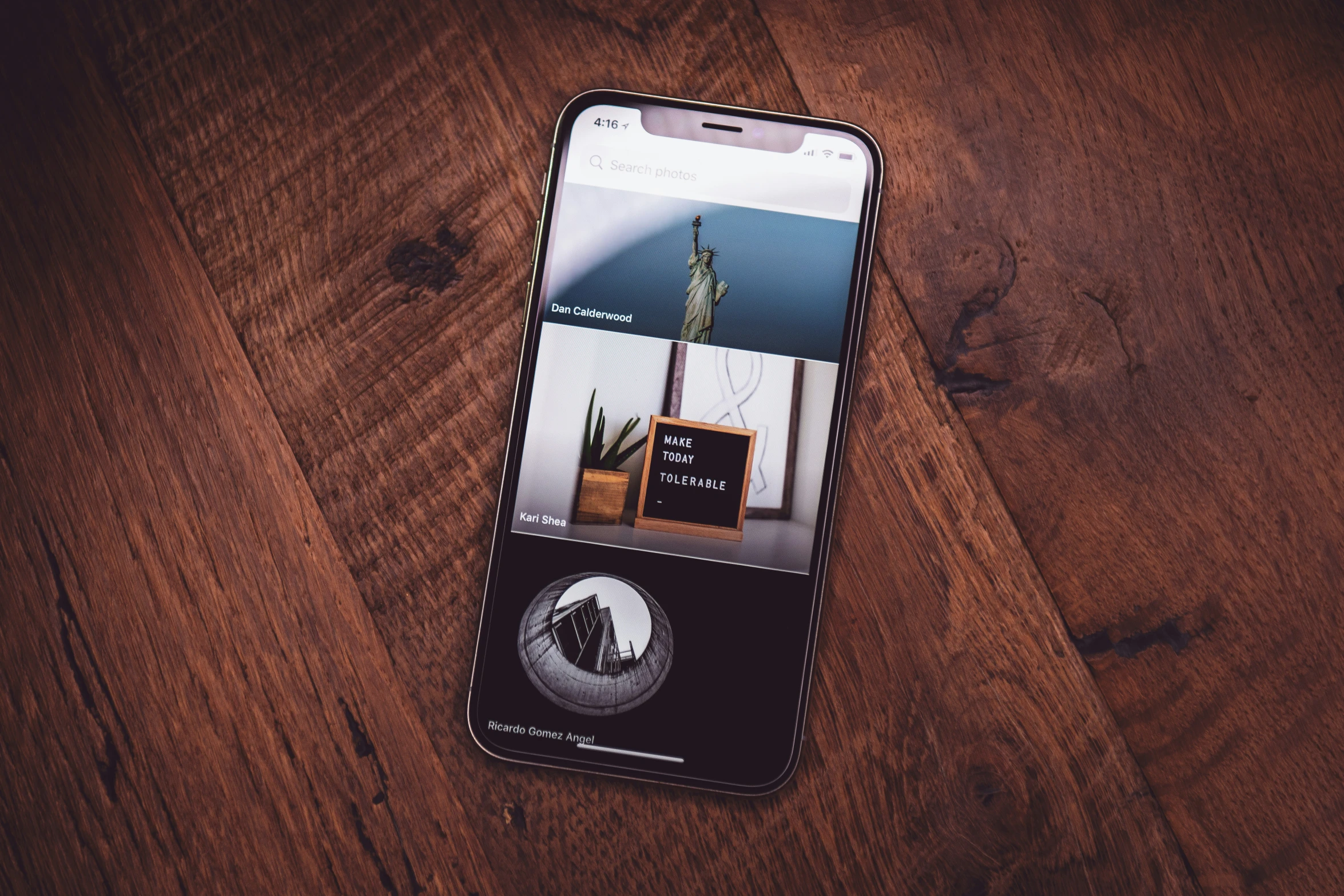 an iphone on a wooden table with the screen turned off