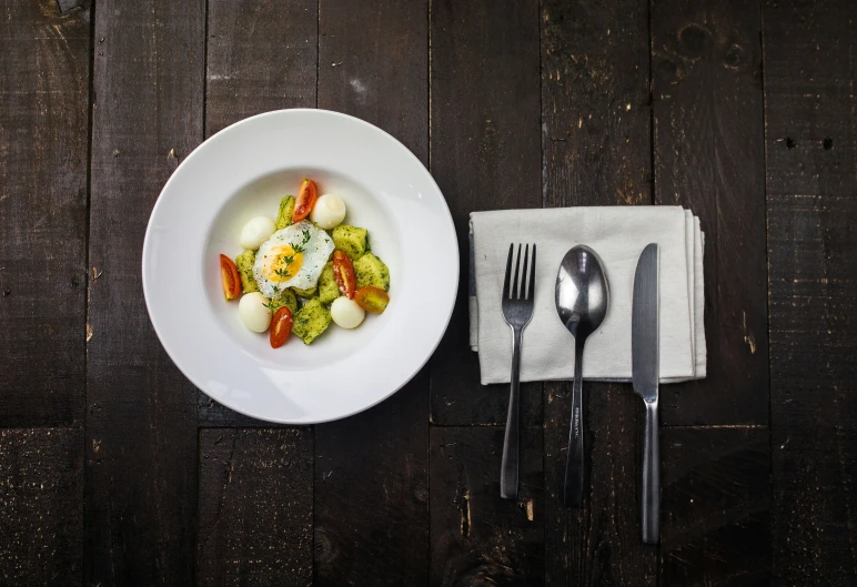 a white bowl of food with an egg and broccoli on top