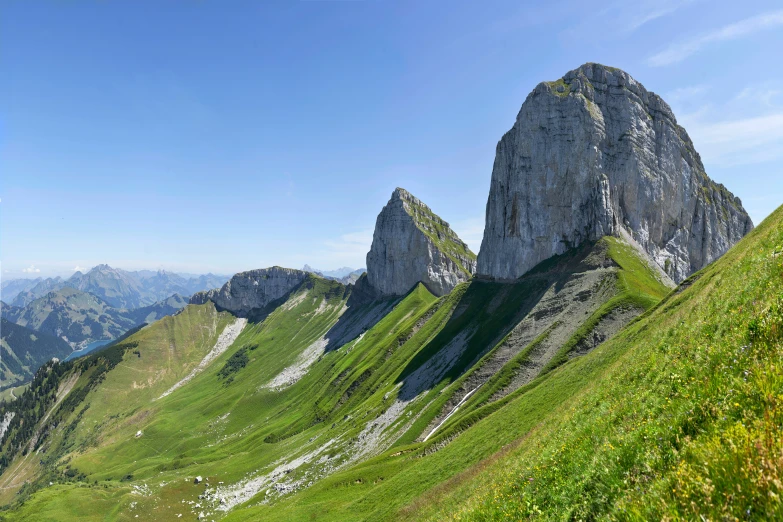 grassy grassy slope on a mountain with two giant mountains