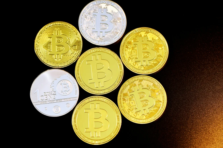 five bitcoins of different color sitting on top of each other