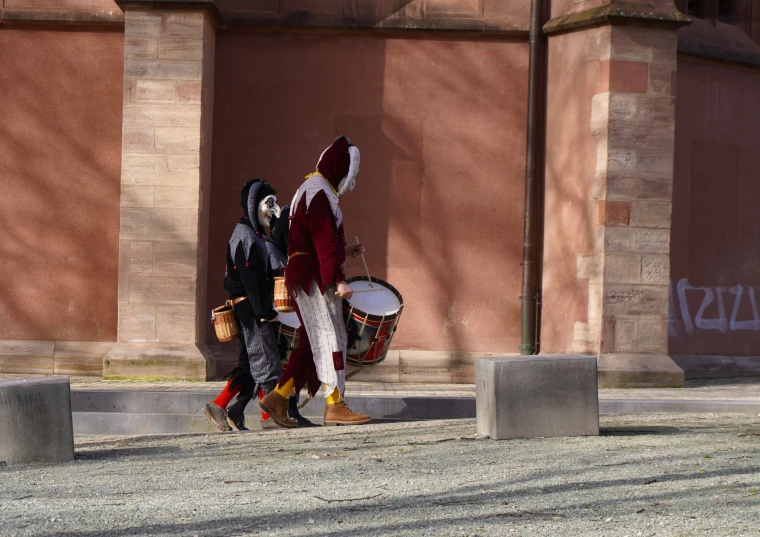 a couple of people that are walking in front of some cement pillars