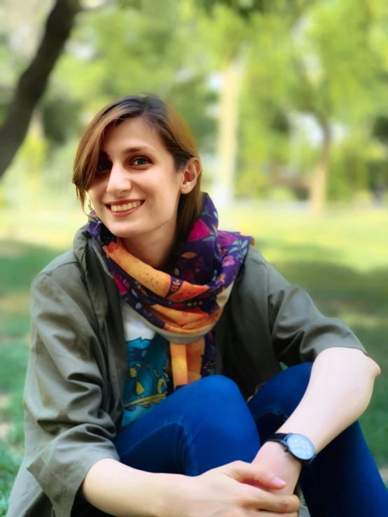 a smiling woman wearing blue pants and a scarf