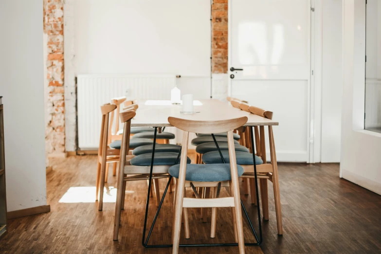 a white table with blue chairs in a large room