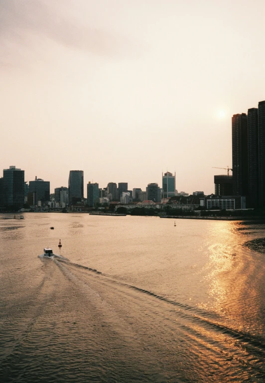 boats floating on the river in front of city