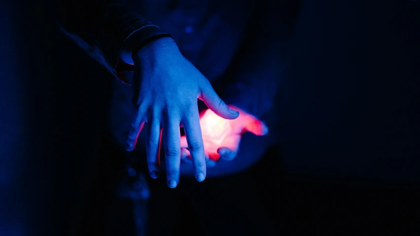 a hand with glowing blue on it with glow colored finger