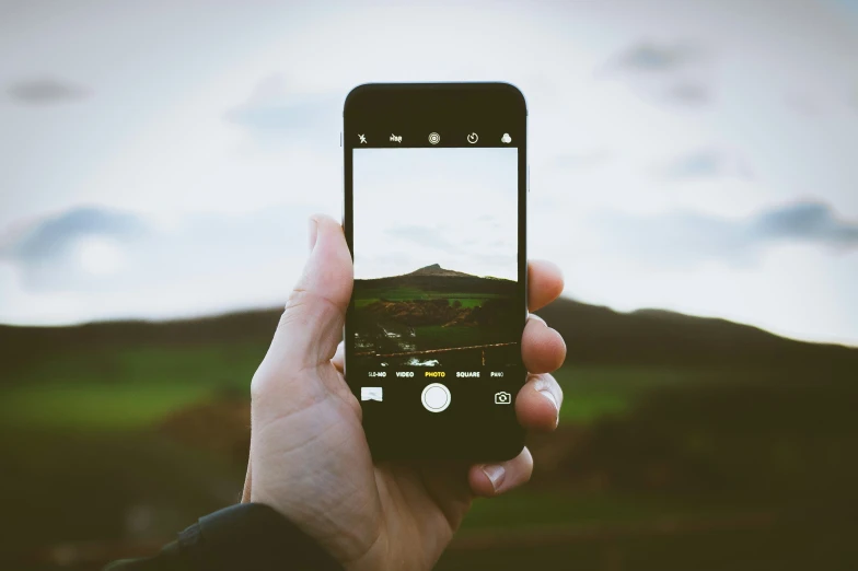 a person taking a picture with their phone in the foreground