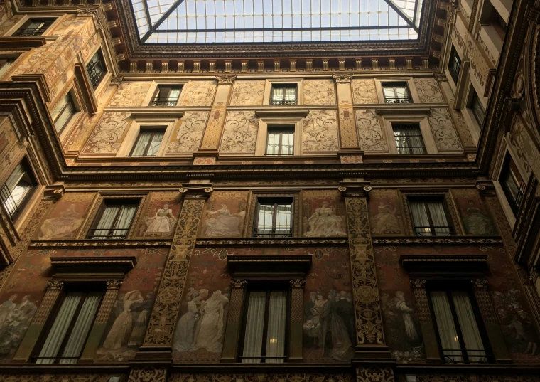 looking up at a tall building with two skylights