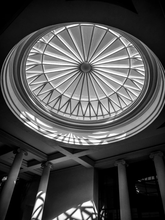 sun shining through a glass dome in a building