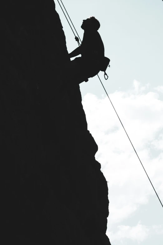 a climber on the side of the cliff during the day