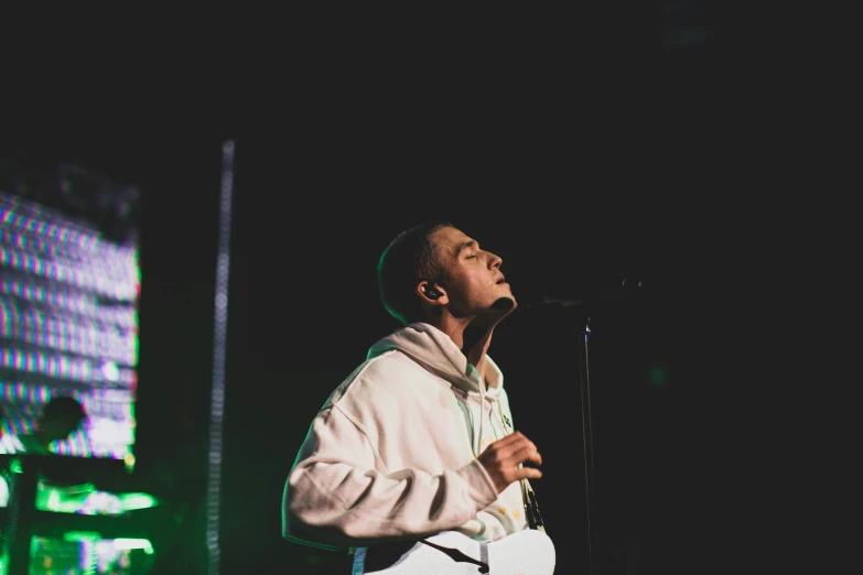 a man singing into a microphone on stage