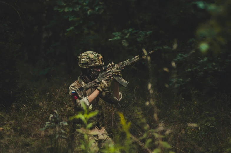 a soldier with a rifle in his hands in the woods