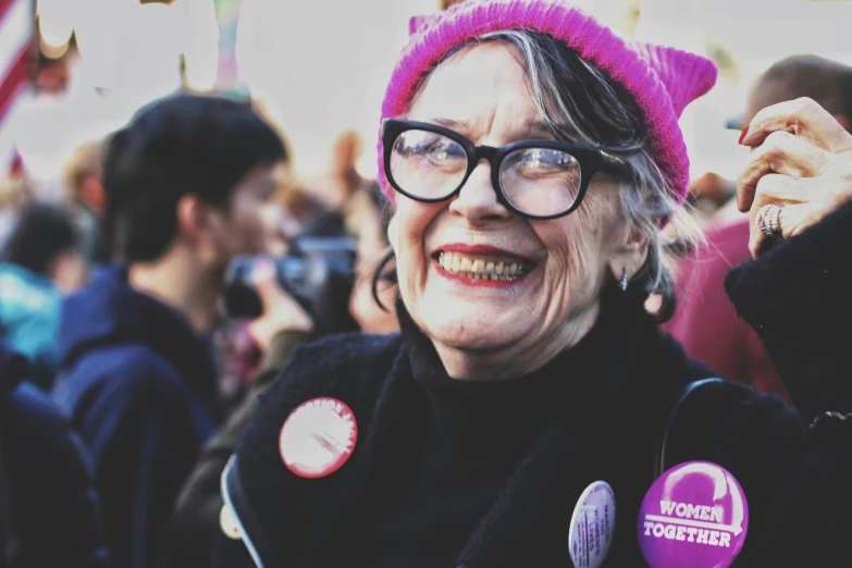 a woman wearing glasses and a pink hat