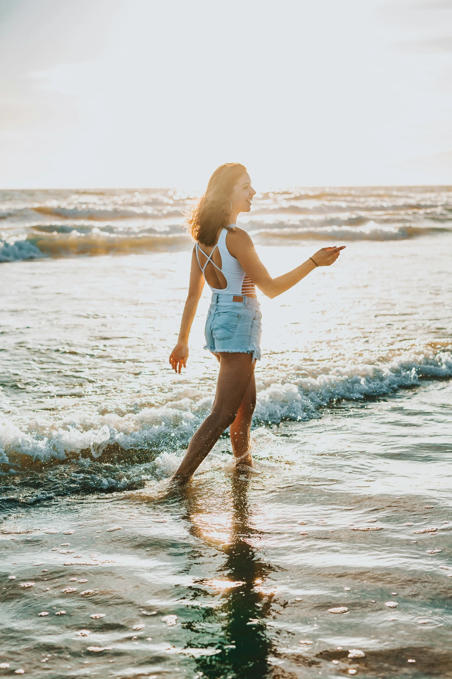 a beautiful young woman standing on top of a beach