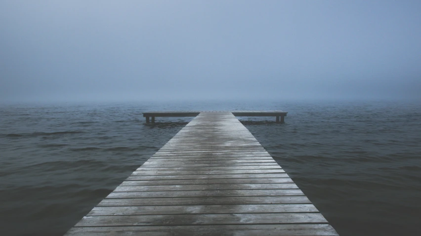 the wooden dock is near the body of water