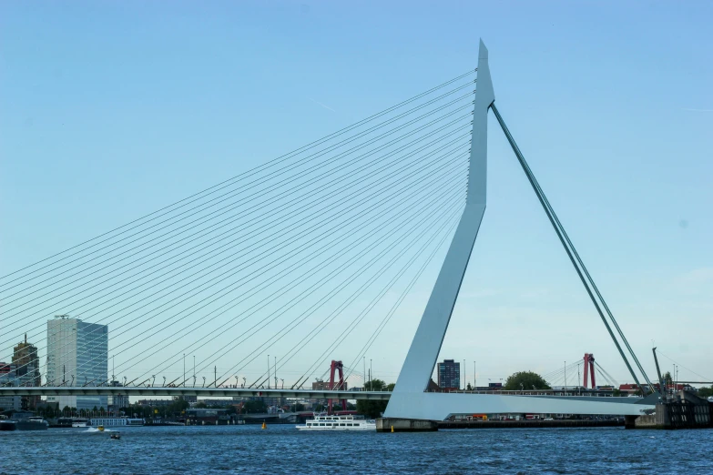 a boat is passing a very modern structure near the water