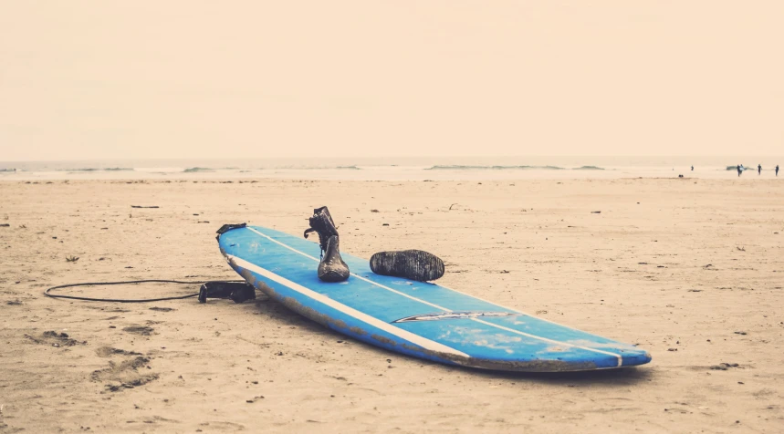 a surf board lays flat on a sandy beach