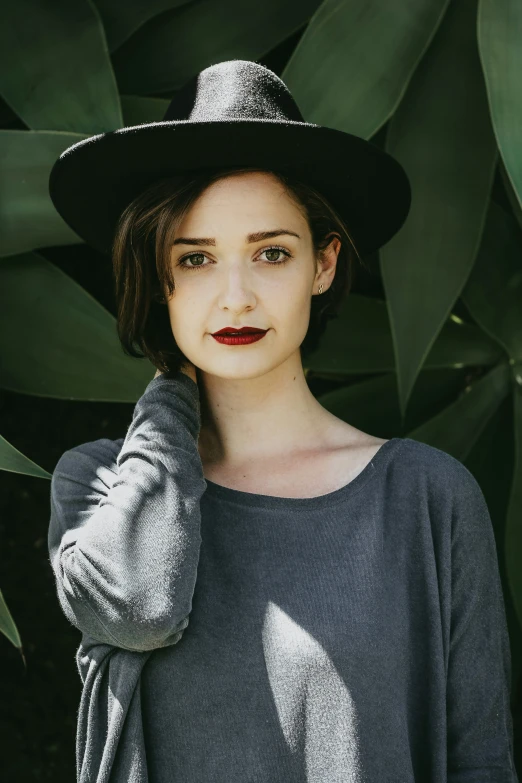 a young woman wearing a black hat with long sleeves