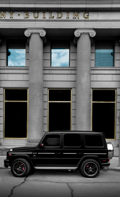 a black vehicle parked in front of an older building