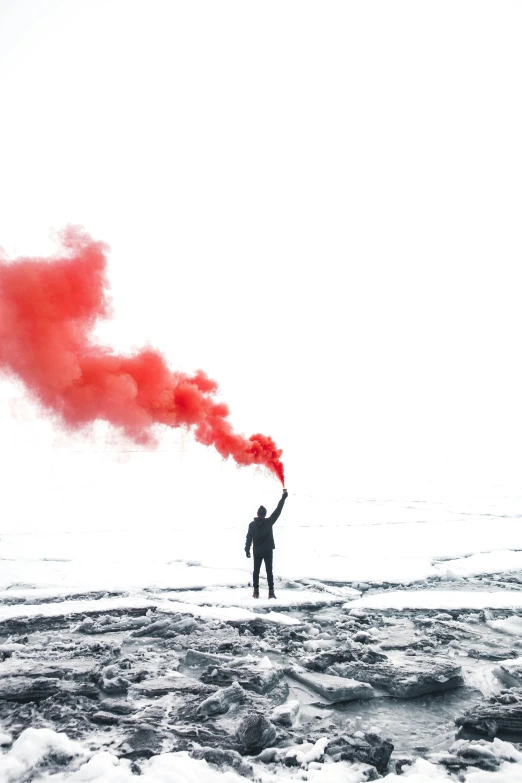 a person is holding red smoke while walking on the beach